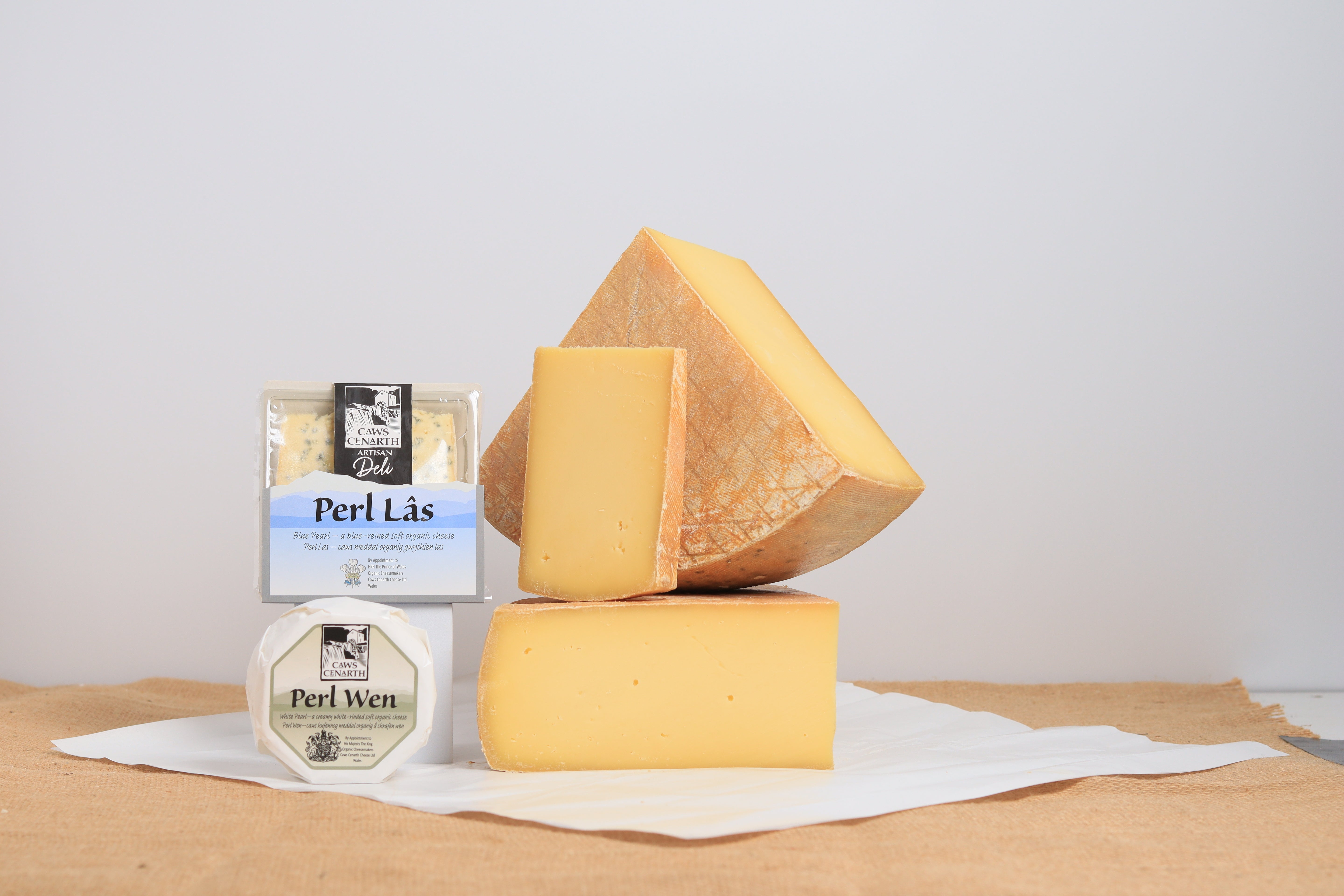 Three types of cheese with visible brand labels on a neutral background