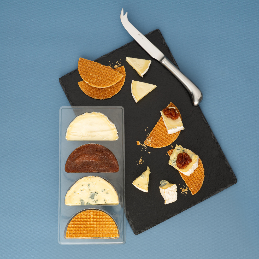 Two Caws Cenarth Cheeses with Tregroes crackers and quince jelly on a slate board with a knife against a blue background