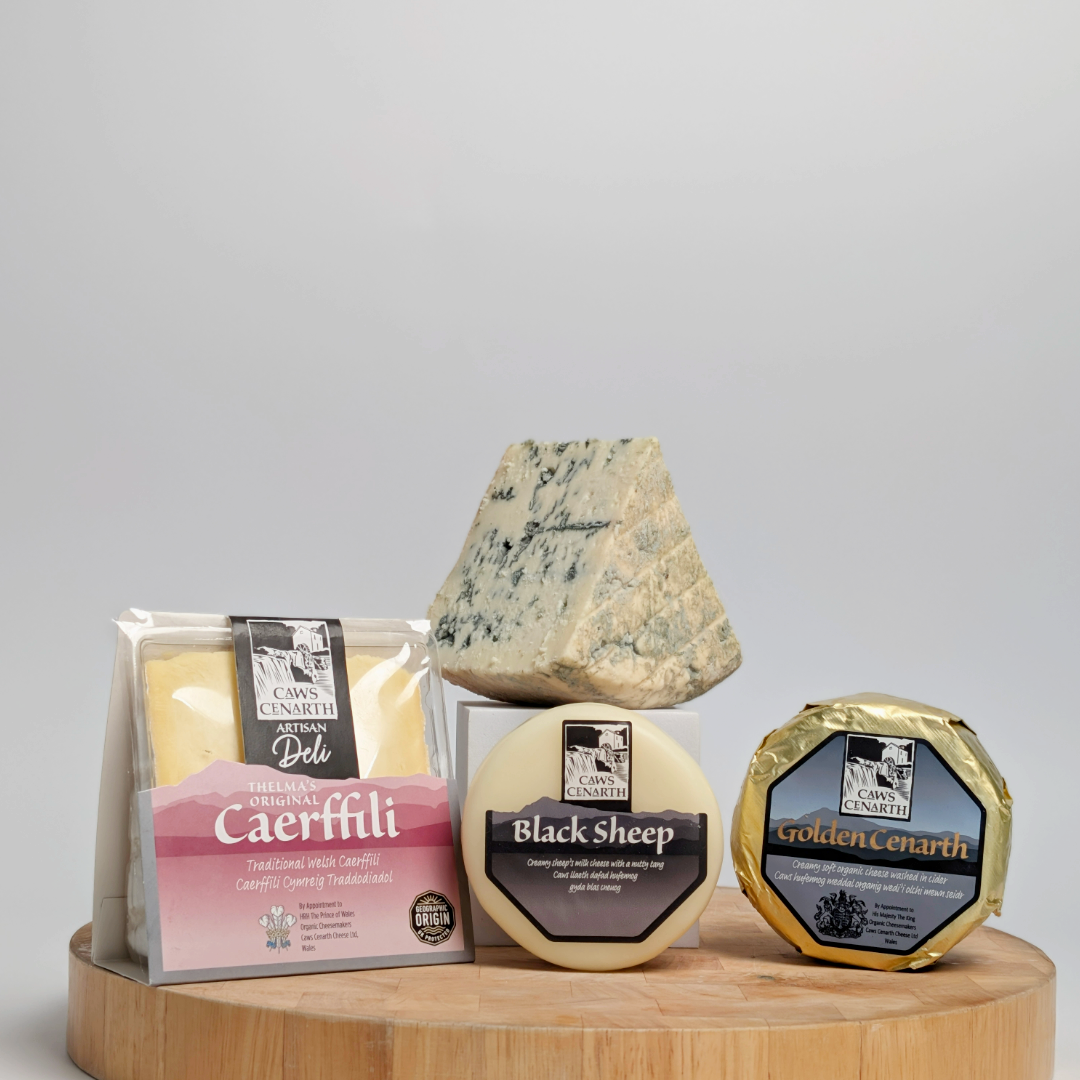 Assorted cheeses on a wooden board with a grey background